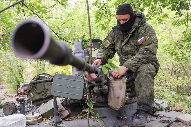 T-72 전차에 올라가 살펴보는 러시아 군인./ 연합뉴스