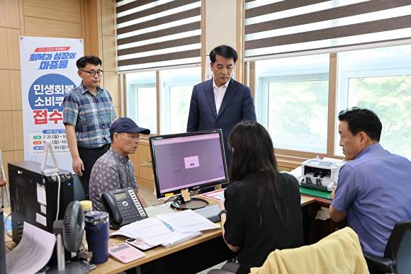 최재형(뒷줄 오른쪽) 군수가 한 행정복지센터에서 민생회복 소비쿠폰 신청 상황을 점검하고 있다. [사진=보은군]
