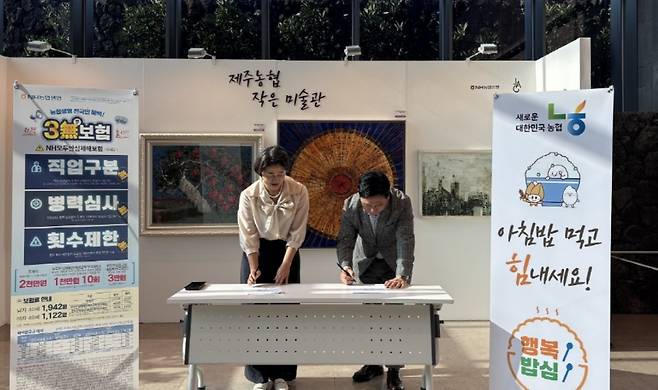 고우일 제주농협 본부장(오른쪽)과 고은정 농협은행 제주본부장이 4일 각각 재해보험 상품에 1호 가입자로 서명하고 있다. (제주농협 제공)