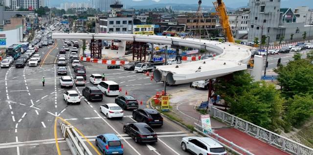 ▲ 휴일인 3일 춘천 소양2교 인근 호반사거리에 188m 길이의 원형 육교를 설치하는 작업으로 이 일대가 극심한 교통체증을 겪고 있다.  최보권 기자