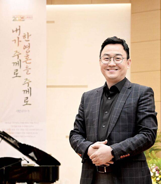 장영환 염광교회 목사가 최근 서울 은평구 교회 예배당에서 올해 교회 표어가 새겨진 현수막을 배경으로 두 손을 모으고 있다. 신석현 포토그래퍼