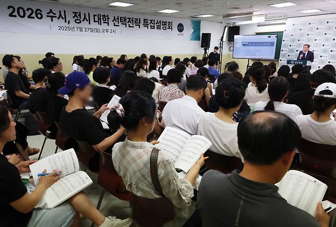 지난달 27일 서울 강남구 대치동 종로학원에서 열린 ‘2026 수시, 정시 대학 선택전략 특집 설명회’에 참석한 학부모와 학생들이 임성호 종로학원 대표이사의 설명을 듣고 있다. [연합뉴스]
