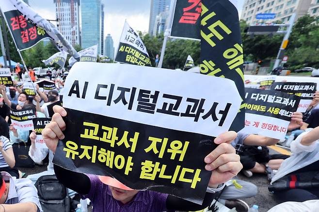 한국교과서협회 회원들이 지난달 21일 오전 서울 영등포구 여의도 국회의사당역 앞에서 열린 초중등교육법 개정안 규탄 집회에서 AI 디지털교과서(AIDT)의 ‘교과서’ 지위 유지를 촉구하고 있다. 뉴스1