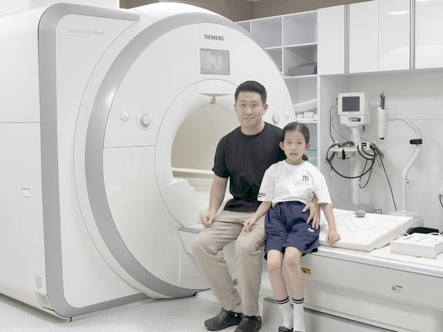 한국뇌연구원 정민영 박사가 그의 딸과 함께 MRI 기기에 앉아 있다. 정민영 박사 제공