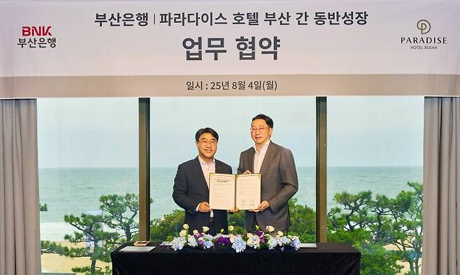 BNK부산은행 방성빈 은행장(왼쪽), 파라다이스호텔부산 최종환 대표이사가 지난 4일 부산 해운대 파라다이스호텔부산에서 기념촬영을 하고 있다. BNK부산은행 제공