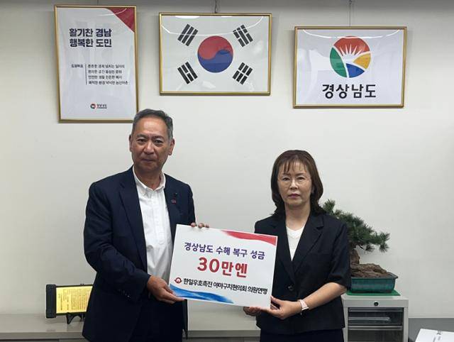 도모다 다모츠(왼쪽) 일본 야마구치현의회 한일우호촉진연맹 회장이 5일 경남도 도쿄사무소를 방문해 이수진 경남도 도쿄사무소장에게 수해 복구 성금을 전달하고 있다. 경남도 제공