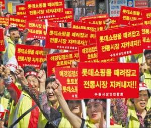 롯데몰 수원점(현 타임빌라스 수원) 개점을 앞둔 2014년 9월 경기 수원역광장에 지역 22개 전통시장 상인들이 모여 쇼핑몰 개점을 반대하는 대규모 집회를 열었다. 당시 상인들은 ﻿피해보상금으로 500억원을 요구했다.   연합뉴스