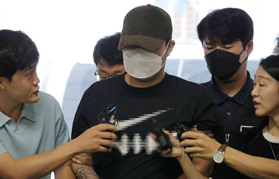 A man in his 20s accused of murdering his ex-girlfriend in Daejeon enters the Daejeon Seobu Police Station on Aug. 5. [YONHAP]