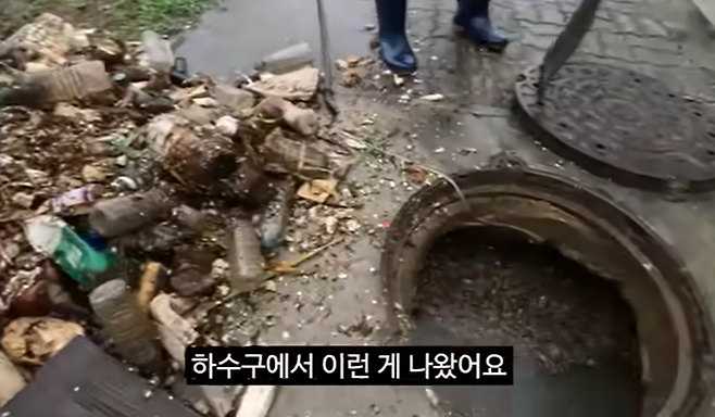 김선태 주무관이 막힌 하수구에 있던 각종 쓰레기를 보여주고 있다. [사진 = 충주시 유튜브]
