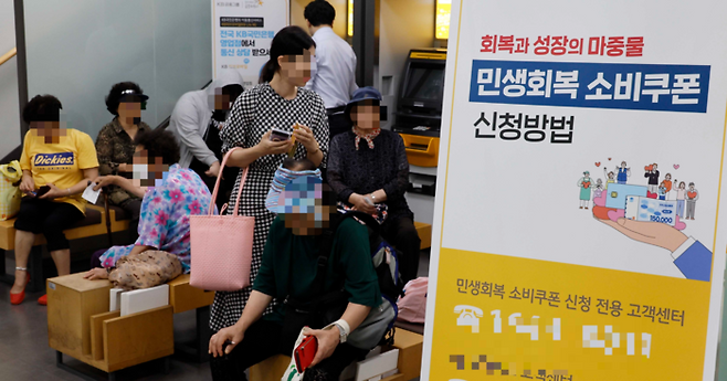 민생회복 소비쿠폰 신청이 시작된 지난달 21일 서울 중구 KB국민은행 약수역 종합금융센터에서 시민들이 소비쿠폰 신청 순서를 기다리고 있다. [김호영 기자]