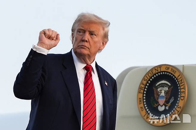 [펜실베이니아=AP/뉴시스] 도널드 트럼프 미국 대통령이 인도의 러시아산 석유 구매를 비판하며 대(對)인도 관세 인상을 시사했다. 사진은 트럼프 대통령이 3일(현지 시간) 미 펜실베이니아주 앨런타운 리하이밸리 국제공항에서 전용기에 탑승하며 주먹을 쥐는 모습. 2025.08.05.