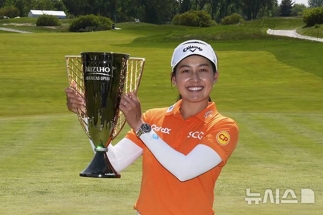 [저지시티=AP/뉴시스] 지노 티띠꾼(태국)이 11일(현지 시간) 미 뉴저지주 저지시티 리버티 내셔널GC에서 열린 미국여자프로골프(LPGA) 투어 미즈호 아메리카 오픈 정상에 올라 트로피를 들고 포즈를 취하고 있다. 티띠꾼은 최종 합계 17언더파 274타로 우승하며 투어 5승째를 올렸다. 2025.05.12.
