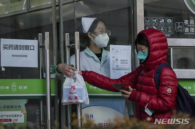 [베이징=AP/뉴시스] 중국 남부 광둥성을 중심으로 치쿤구니야열이 확산하는 가운데, 포산시 당국이 관련 의약품 구매 시 실명 등록제를 시행 중인 것으로 뒤늦게 확인됐다. 사진은 2022년 11월 11일 중국 베이징의 한 약국에서 약국 직원이 문틈으로 고객에게 약품을 전달하는 모습. 2025.08.05