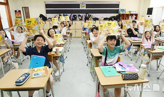 [수원=뉴시스] 김종택 기자 = 5일 여름방학을 마치고 개학한 경기 수원시 영통구 잠원초등학교 4학년2반 학생들이 새학기 교과서를 들어 보이며 즐거워하고 있다. 2025.08.05. jtk@newsis.com