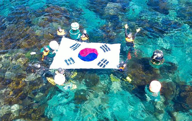 제주 해녀들이 2024년 9월 5일 50년만에 경북 울릉군 독도를 찾아&nbsp;물질시연을 한 뒤 태극기를 펼쳐 보이고 있다. 제주도 제공
