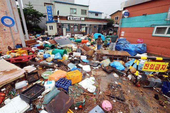 지난 4일 오전 전남 함평군 함평천지전통시장에서 상인들이 수해 복구 작업을 하고 있다. 함평에는호우특보가 발효된 전날 하루 동안 170여㎜의 비가 내렸다. ⓒ연합뉴스