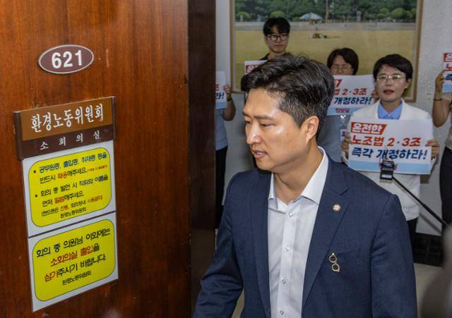 전종덕 진보당 의원(뒷줄 오른쪽)이 지난달 28일 국회 환경노동위원회 법안소위가 열린 소회의실 앞에서 손팻말을 들고 여야 의원들에게 '온전한 노조법 2·3조(노란봉투법) 즉각 개정'을 촉구하고 있다. 연합뉴스
