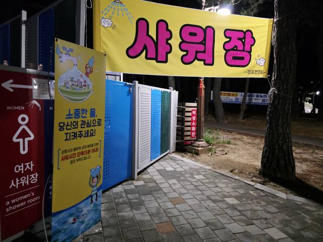 ▲ 경포해수욕장 샤워장에 설치된 샤워 시간 단축 협조 안내 문구. 황선우 기자