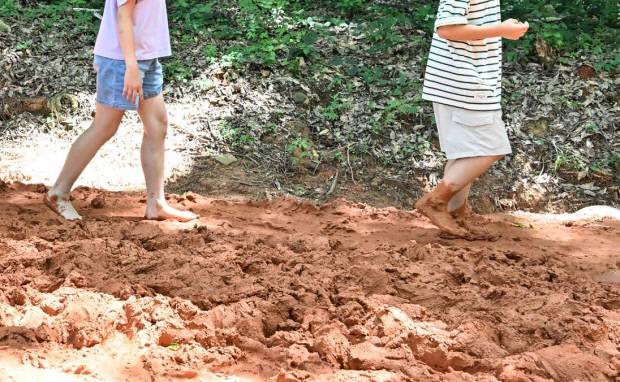 물무산 ‘질퍽한 맨발 황톳길’을 걷고 있는 아이들. <최현배 기자>