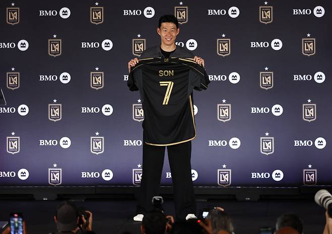 (손흥민이 7일(한국시간) LA FC 입단기자회견장에서 자신의 유니폼을 들고 포즈를 취하고 있다)