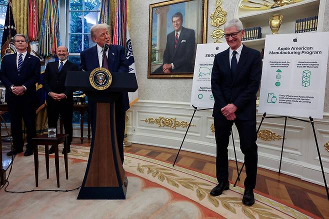 애플 CEO 팀 쿡이 도널드 트럼프 미국 대통령 연설을 들으며 웃고 있다. /연합뉴스