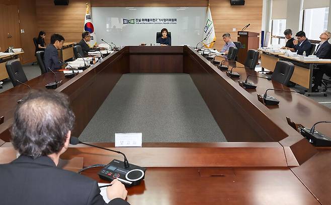 5일 오후 열린 진실화해위 제114차 전체위원회에서 정영훈 조사2국장(뒤돌아선 이)이 인권침해 사건 종합보고서 초안에 관해 보고하고 있다. 진실화해위 제공