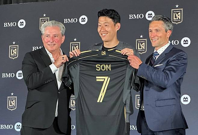 손흥민이 7일(한국시간) 미국 로스앤젤레스(LA) BMO 스타디움에서 열린 LAFC 기자회견에서 베넷 로즌솔 공동 구단주(왼쪽), 존 소링턴 회장과 함께 등번호 7번이 새겨진 유니폼을 보여주고 있다. 연합뉴스