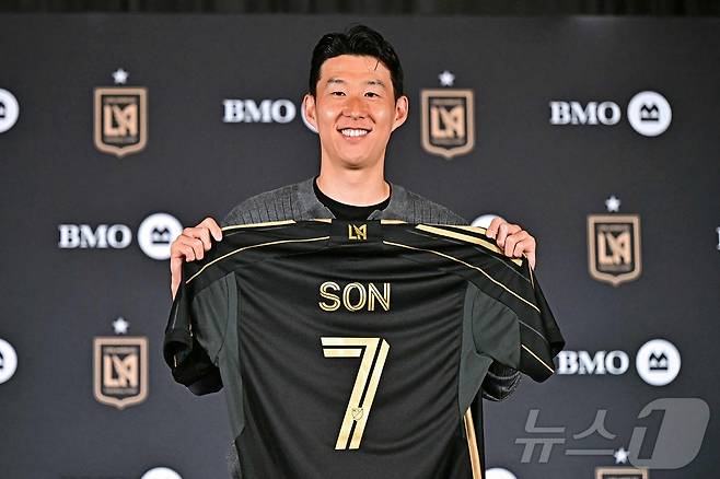 손흥민이 6일(현지시간) 로스앤젤레스 BMO 스타디움 필드 클럽에서 열린 로스앤젤레스 FC(LAFC) 입단 기자회견에서 7번 유니폼을 들고 미소를 보이고 있다. 구단에 따르면 계약 기간은 2027년까지이며, 옵션에 따라 2029년까지 연장할 수 있다. ⓒ AFP=뉴스1