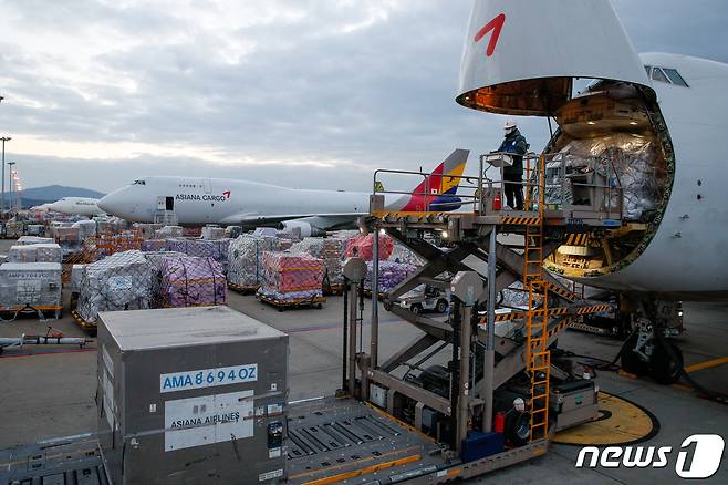 인천국제공항 아시아나항공 화물터미널에서 2021년 12월 아시아나항공 관계자들이 화물기에 화물을 싣고 있는 모습<자료사진>.(사진은 기사 내용과 무관함). 2021.12.19/뉴스1 ⓒ News1 안은나 기자