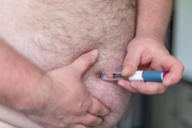 한 환자가 주사형 비만치료제를 스스로 배에 주입하고 있다. 게티이미지뱅크