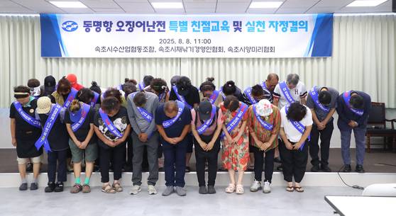 Merchants from a squid street market in Sokcho, Gangwon, hold a "self-reform meeting" at the local fishery cooperative on Friday to apologize for alleged poor customer service. [YONHAP]