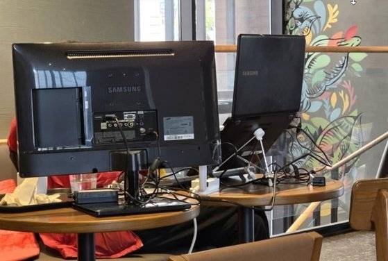 국내 스타벅스 한 매장에서 한 고객이 컴퓨터 모니터와 노트북 등 온갖 개인 장비를 들고 테이블 두개를 사용해 개인 업무를 하고 있다. 자료 : 엑스