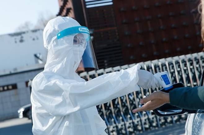 체온 재고 있는 의료진. 게티이미지뱅크