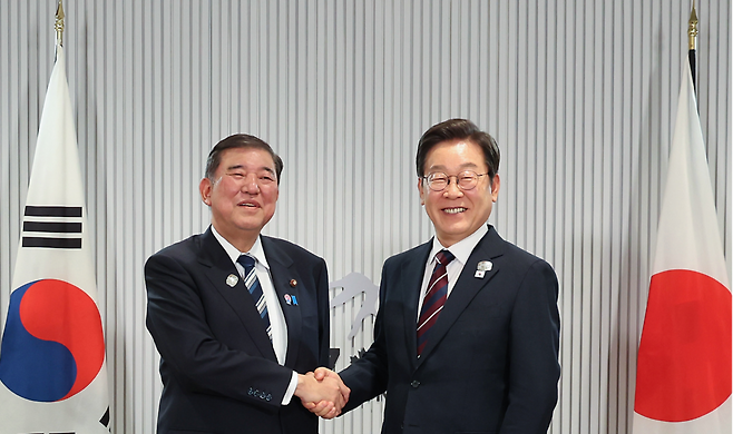이재명 대통령이 지난 6월17일(현지시간) 캐나다 앨버타주 캐내내스키스 주요 7개국(G7) 정상회의장에서 열린 한일 정상회담에서 이시바 시게루 일본 총리와 악수하며 기념촬영을 하고 있다. 연합뉴스