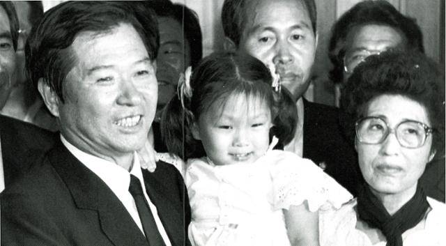 1987년 7월 9일 김대중(왼쪽) 전 대통령이 2,335명에 대한 특별사면 및 복권조치를 10일 0시를 기해 단행한다는 정부 발표를 듣고 자택에서 부인 이희호(오른쪽) 여사와 함께 손녀딸을 안고 기자들에게 둘러싸여 환한 웃음을 띠고 있다. 한국일보 자료사진