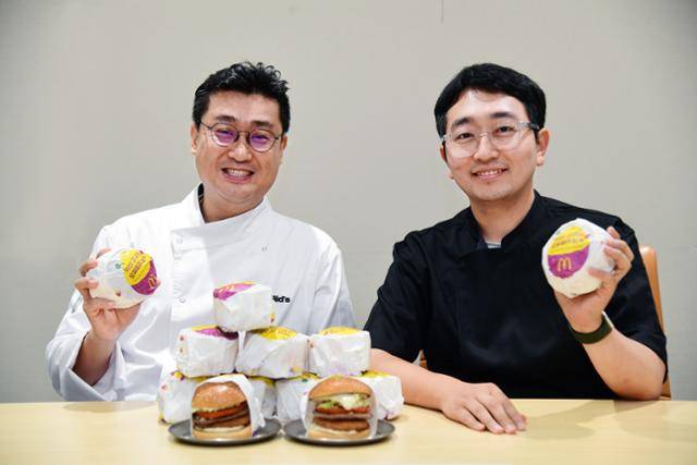 한국맥도날드 메뉴 개발팀의 백창호(왼쪽) 팀장과 이충희 컨설턴트가 올해 출시한 익산 고구마 모짜렐라 버거를 들어 보이고 있다. 한국맥도날드 제공