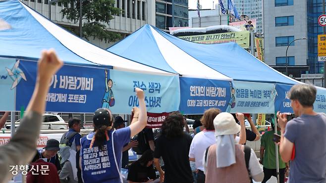 정리해고 철회를 요구하며 지난 2월부터 고공농성 중인 고진수 민주노총 세종호텔 지부장의 서울 중구 세종호텔 고공 농성장 앞에서 10일 열린 연대 행사에서 참가자들과 고 지부장이 함께 구호를 외치고 있다. 정효진 기자