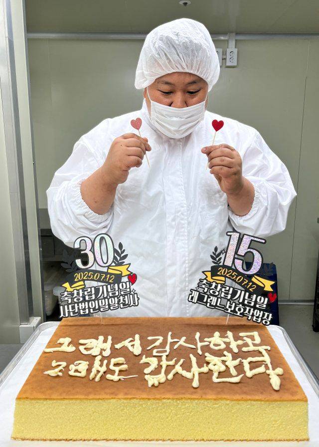 서울 강남구 래그랜느 사업장에서 산행 30주년 기념 케이크 앞에 선 남기철 대표 아들. 남 대표 제공