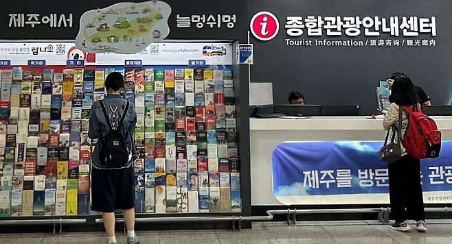 지난 6월 관광객으로 보이는 이들이 제주국제공항에 1층 도착장에 설치된 종합관광안내센터에서 비치된 자료를 둘러보고 있다. 문정임 기자