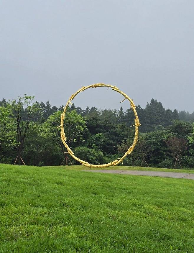 [사진=박현주 미술전문기자]포도뮤지엄 야외에는 우고 론디노네의 burn shine fly가 서 있다. 황금빛 나무 가지로 엮은 거대한 원이, 구름 낀 제주 하늘을 틀어쥔 듯 자연과 호흡한다. *재판매 및 DB 금지