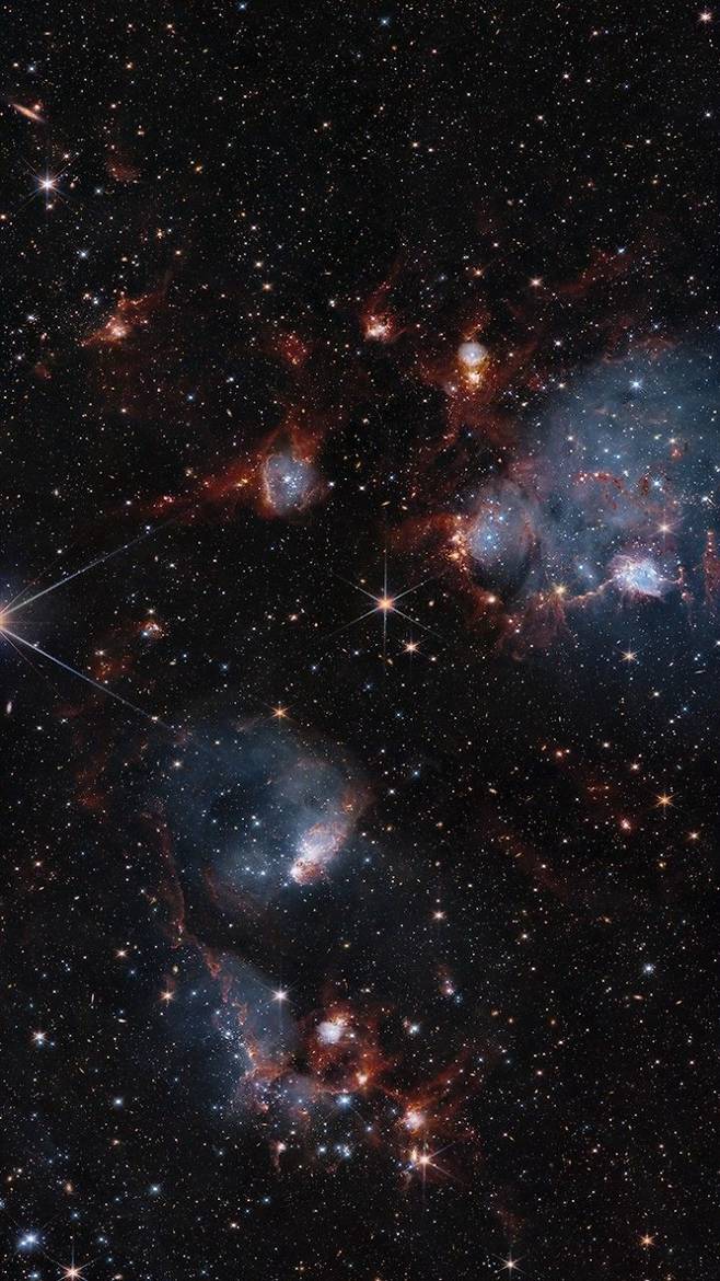 개방성단 NGC 460과 NGC 456이 포함된 왜소 은하인 소마젤란 성운을 관측한 이미지. 허블 우주망원경과 제임스웹 우주망원경의 관측 결과물을 합쳤다. NASA, ESA, and C. 린드버그 (존스홉킨스 대학교); 이미지프로세싱: 글래디스 코버(NASA/미국 가톨릭대학교)