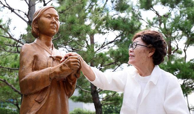 일본군 위안부 피해자인 이용수 할머니가 2024년 8월 14일 대구 남구 대구여자상업고등학교를 찾아 평화의 소녀상을 쓰다듬고 있는 모습. (사진=뉴시스)