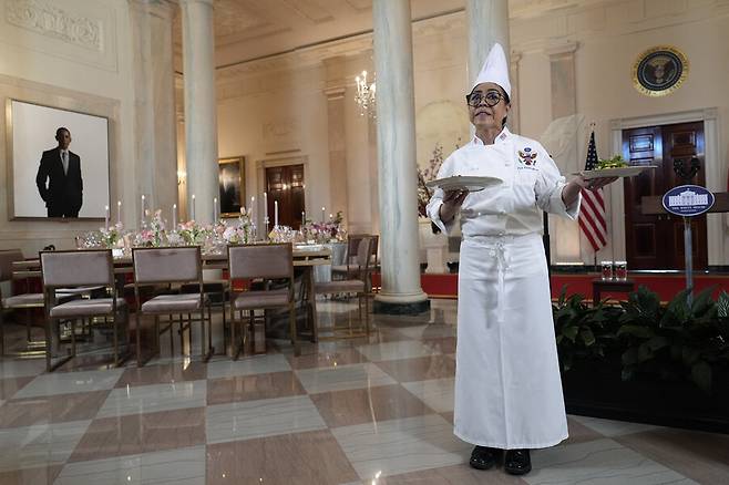 자료사진. 2024년 4월9일(현지시각) 백악관 수석 요리사가 백악관 스테이트플로어 입구 홀에서 다음날 있을 국빈 만찬에 대해 설명하는 기자회견 자리에서 대답하고 있다. 뒤쪽으로 전임 대통령들의 초상화가 보인다. 가장 잘 보이는 왼쪽에 버락 오바마 전 대통령의 초상화가 걸려 있다. 트럼프 대통령은 지난 4월 이 자리에 자신의 초상화를 걸고 오바마 전 대통령의 초상화를 옆으로 옮긴 데 이어, 최근에는 전직 대통령들의 초상화를 계단 꼭대기쪽으로 이동하라고 지시했다고 시엔엔이 10일 보도했다. AP연합뉴스