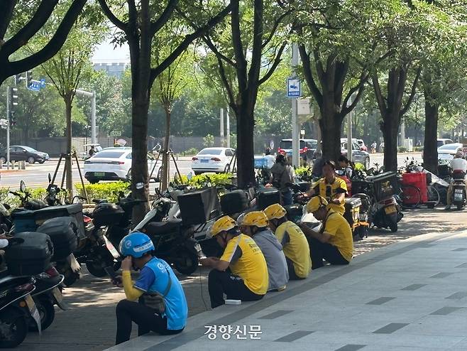 베이징 차오양구의 한 상가 앞에서 여러 플랫폼의 배달기사들이 앉아서 기주문을 기다리고 있다. /박은하 기자