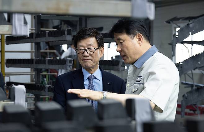 Yoon Jin-sik, left, chairman of the Korea International Trade Association, inspects an auto parts maker's factory in Busan in May. [KOREA INTERNATIONAL TRADE ASSOCIATION]