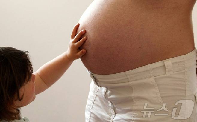 한 아이가 임신부의 배에 손을 올리고 있다. 기사 내용과는 무관한 자료사진/로이터=뉴스1