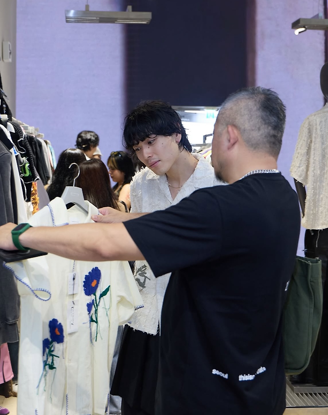 이달 진행된 ‘캠퍼우드’ 팝업 스토어에서 브랜드 크리에이티브 디렉터 타쿠로 쿠스노키(왼쪽)가 소비자와 소통하고 있다. [무신사 엠프티 인스타그램 갈무리]