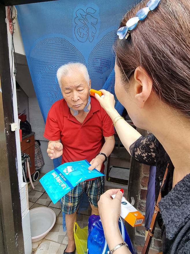 강인옥 통계청 서울사무소 고용통계1팀장이 7월 28일 서울시 광진구 자양4동 조사대상자인 정남열 할아버지를 찾아 통계청에서 제작한 온열예방용품을 전달하고 있다. 강 팀장이 선스틱을 꺼내 정 할아버지에게 발라주며 사용법을 알려주고 있다. [사진=김용훈 기자]