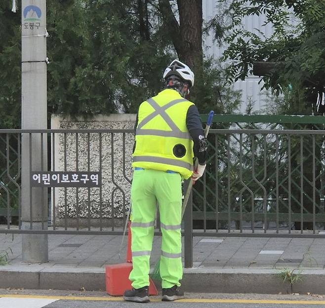 [서울=뉴시스] 도봉구 야외 청소 현업근로자가 선풍기 조끼를 입고 도봉구 지역 내 한 도로를 청소하고 있다. 2025.08.11. (사진=도봉구 제공) *재판매 및 DB 금지