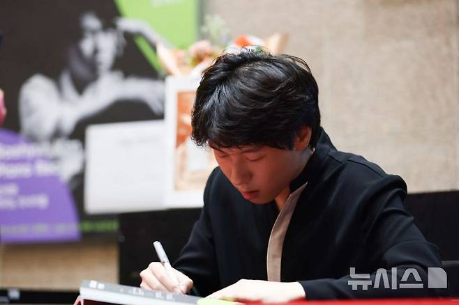 [서울=뉴시스]지난 8일 서울 예술의전당에서 피아니스트 김세현이 독주회를 열었다. 김세현이 독주회가 끝난 직후 사인회를 열어 사인하고 있는 모습. (사진=예술의전당 제공)